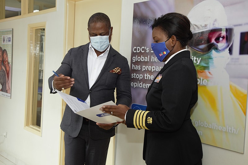 Photo of CDC Cameroon Country Director Dr. Emily Kainne Dokubo and Global Health Security Agenda Coordinator Gordon Okpu standing next to each other and holding paper.