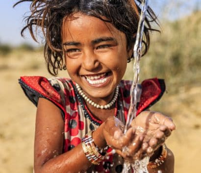 Little girl drinking fresh water in India