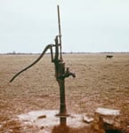 Photo of a well pump in a dirt field
