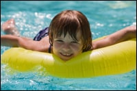 A child floating in a swimming pool.