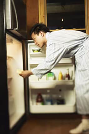 photo of man in front of open refrigerator