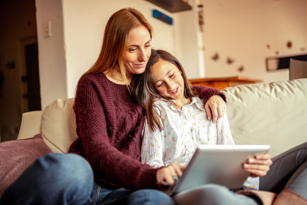 Mother and daughter spending time together using digital tablet