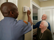 Older Adult Couple with Fireman testing fire alarm