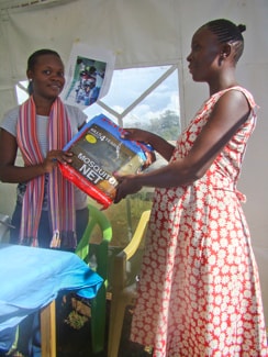 A pregnant woman receives a treated mosquito net during the Intermittent Preventive Treatment of Malaria in Pregnancy Trial in Kenya’s Siaya District Hospital.