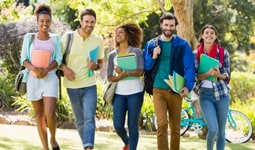 The image above is a photograph of a group of college students walking on campus.