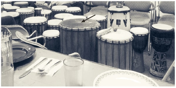The figure shows drums placed in an event room of a community organization building before a meal and drumming circle event in New Hampshire on December 4, 2009. A total of 72 persons attended the December 4 event, and a total of 59 drums were present, including 17 drums that participants brought from home. Volunteers set up drums and prepared a vegetarian meal; participants ate dinner in the main drumming room before beginning the drumming circle, which lasted 2 hours.