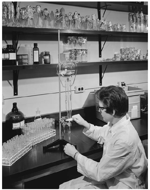 The picture is a photo of a CDC worker in a lab using the manual method for checking a sample for cholesterol in 1966. 