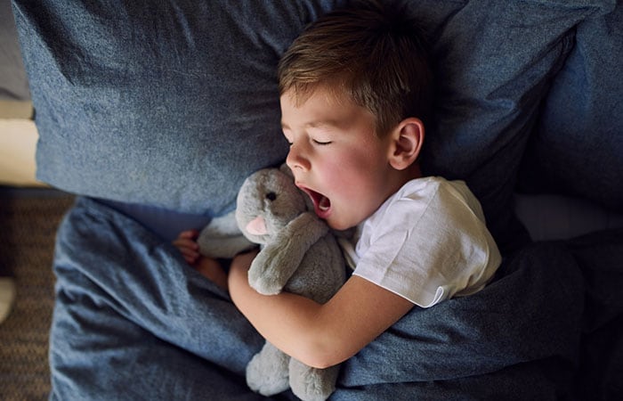 Child sleeping with a toy stuffed animal