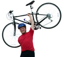 Hombre cargando una bicicleta por encima de su cabeza