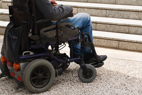 Persona en silla de ruedas al comienzo de las escaleras