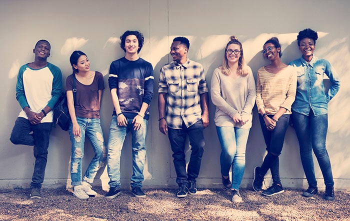 Diverse group of friends standing against a wall