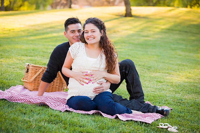 Pareja hispana embarazada en el parque
