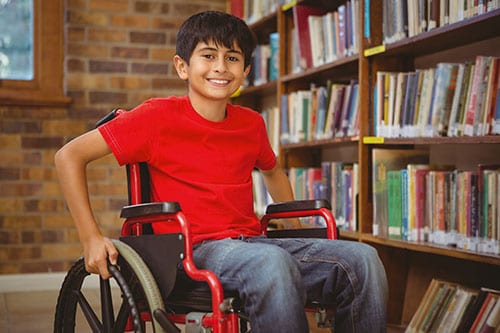 Un niño en una silla de ruedas en la biblioteca