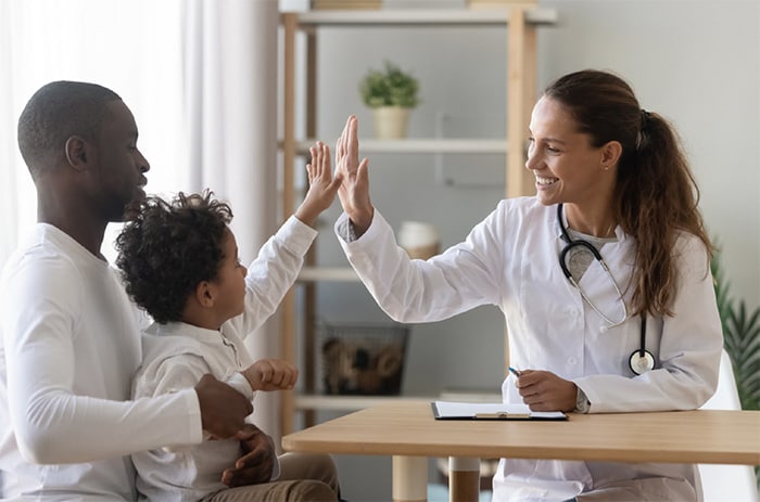 Doctor giving young boy a high five