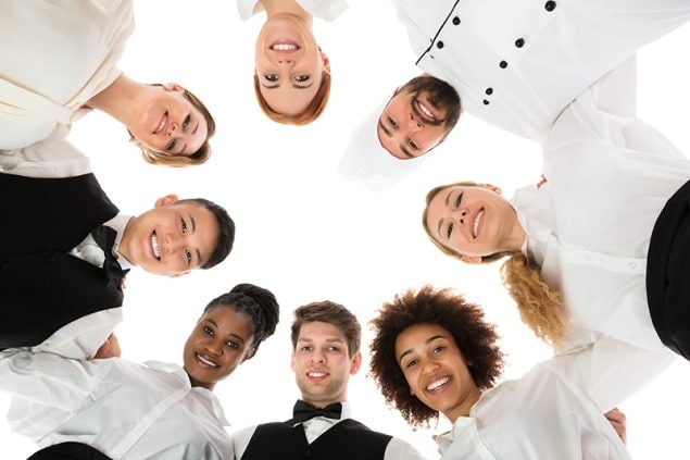 Low Angle View Of Happy Restaurant Staff Forming Huddle
