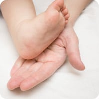 Hand holding baby's foot