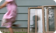 Girl running past paint-chipped windows