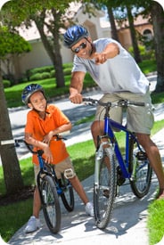 A boy and his father riding bikes