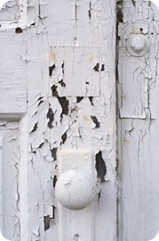 Paint flaking off of an old door with handle