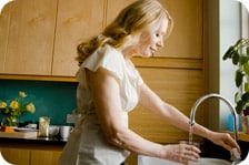 Woman filling glass with water from tap