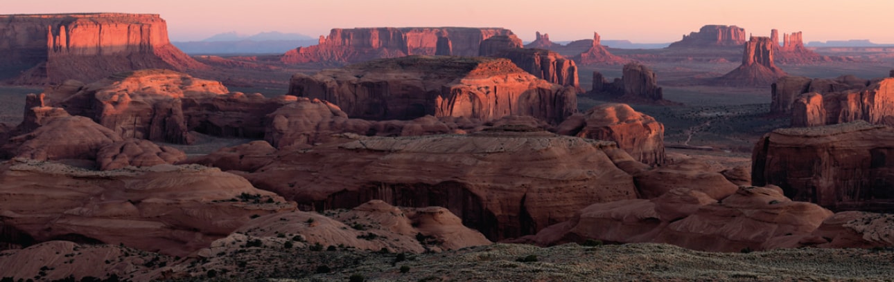 Wide panoramic shot of colorful canyons in the southwest as the sun sets