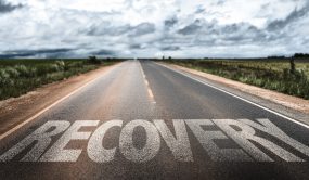 the word recovery painted on a road