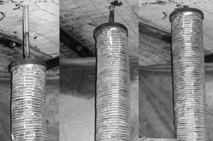Three black and white pictures of a section of mine ceiling. The ceiling is buttressed by wire mesh and steel angle iron and the pictures are taken from the same position over time. In the foreground of all three pictures is a roof bolting drill bit, surrounded by a collapsible drill steel enclosure(CDSE), as it drills into the mine ceiling. In each picture the CDSE moves closer to the mine ceiling.