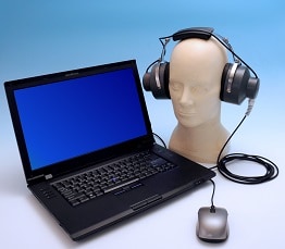 NIOSH HPD Well-Fit™ fit-testing system for earplugs shown with laptop and manikin with headphones.