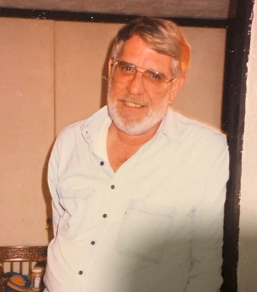 Photo of older white male in white shirt smiling at camera