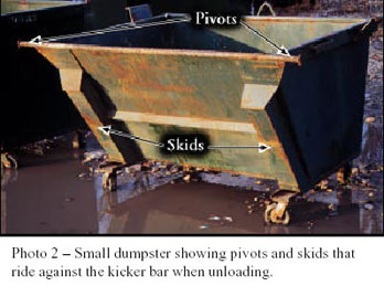 Photo 2 - Small dumpster showing pivots and skids that ride against the kicker bar when unloading.