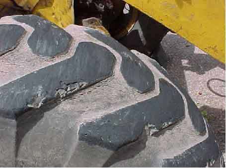 Photo 10.  Right front-drive tire.  Note missing tread and chunks of rubber.