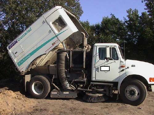 Figure 4a. Sweeper with hopper raised showing space between side of hopper and top of suction hose.
