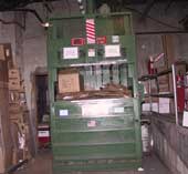 A vertical down-stroke baling machine.