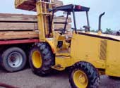 Forklift loading lumber onto truck.