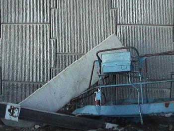Attachment 3. Man lift personnel basket with concrete “cap” across railing.