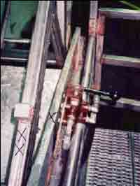the arm of the tote dump and the upper edge of the hopper