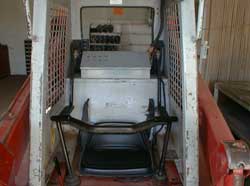 Figure 2. View of cab with seatbelts and restraint bar.