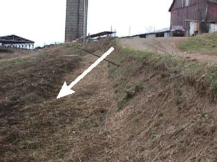 Figure 3.  This photo shows the 4 foot bank which both the right front and right rear wheels dropped off, causing the tractor to roll and land upside-down on the victim.