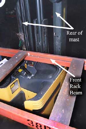 Photo 4 - View from behind the rack beam showing the operator’s work area, machine controls on the console, and the unprotected rear corner of the machine.