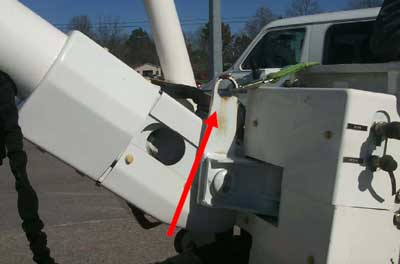 Photograph depicts the attachment of the boom to the bucket and the eye hook for harness attachment.