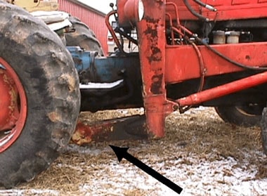 Figure 3. The arrow represents the victims position while removing the last nut located under the right rear axle. He was on his back with his chest directly below the component identified by the arrow.
