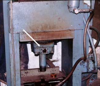 The lower front part of the shop-fabricated hydraulic press involved in this incident shows a hole where a hose was attached to the hydraulic cylinder.
