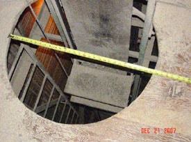 The victim fell through this manlift shaft opening. A platform step is shown on the lift belt, and the fixed ladder and stop cord at left. 