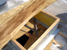 Figure 4. Chase A exhaust fan hole with 2x4 lumber and plywood boards as cover. 