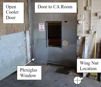Figure 1. Outer door, inner aluminum door, Plexiglas window, opening to CA room, warning sign, wing nuts location.