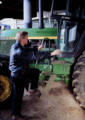 photo shows person maintaining &quot;three point contact&quot; while climbing on the tractor steps