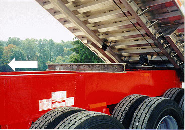 photo shows metal alternative after-market body prop laying on truck frame under body