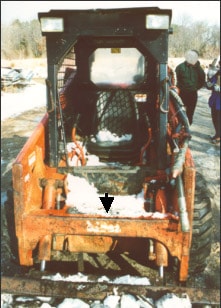 arrow points to cross member of boom lift-arm assembly of skid steer loader