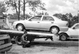file photo of a flatbed unloading a car