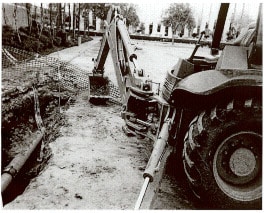 photo shows image of bucket and boom of backhoe